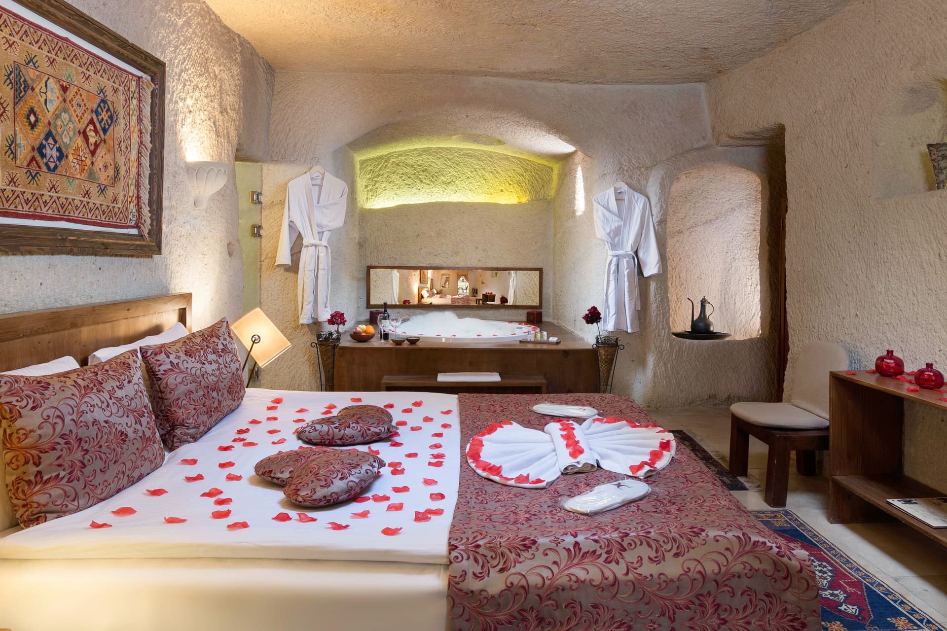 Room 111, King Cave Suite: another angle of the same setup: the bed, rose petals, and the swan-folded towel