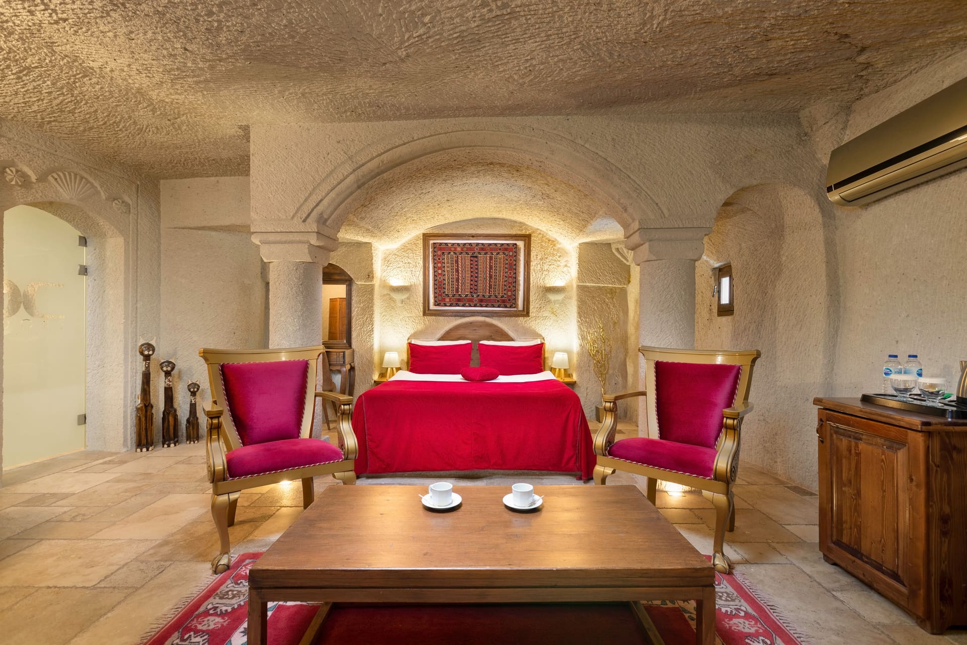 Room 115, Junior Cave Suite: arched cave ceiling, burgundy chairs, coffee cups on the table