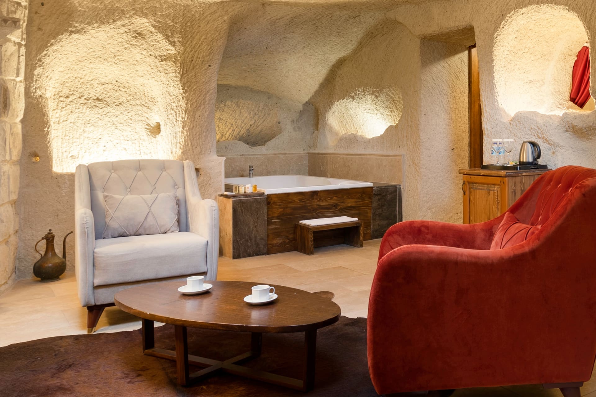 Room 106, King Cave Suite: the same lounge area from another angle, showing the jacuzzi tub in a stone niche
