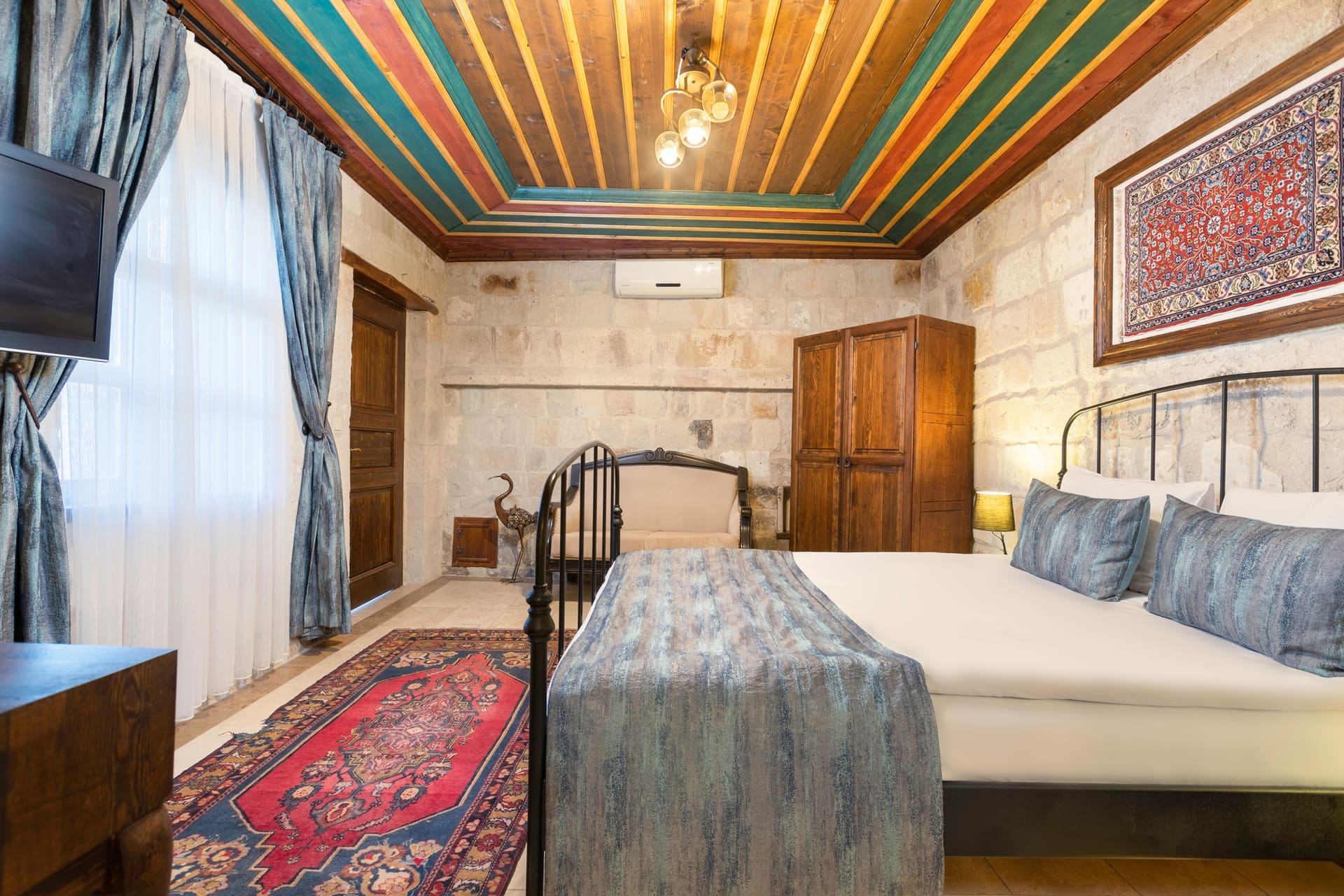 Room 101, Deluxe: View from the window toward the double bed, painted wooden ceiling, wardrobe