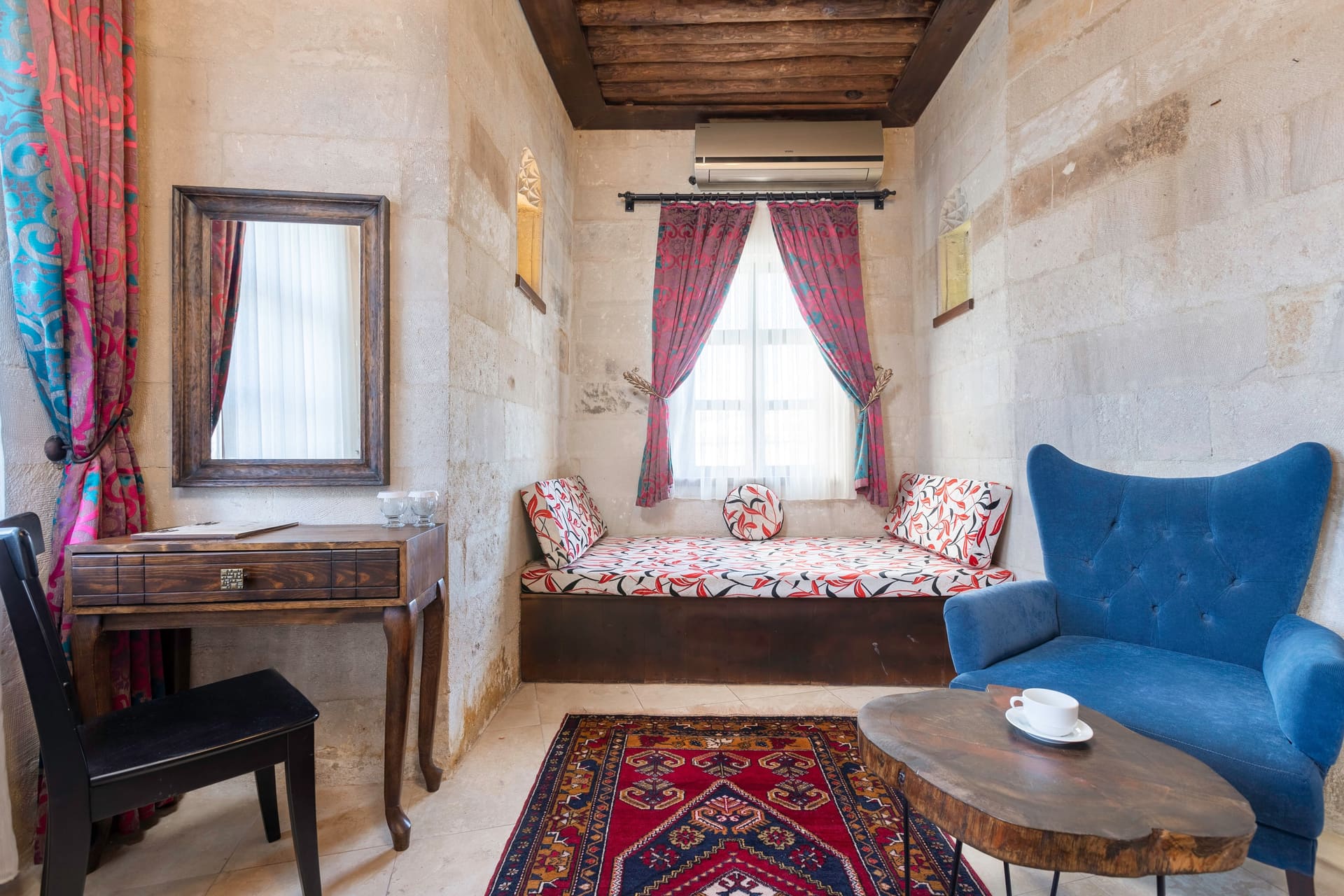 Room 102, Junior Suite: Wooden desk and chair, blue upholstered bench, window seat.