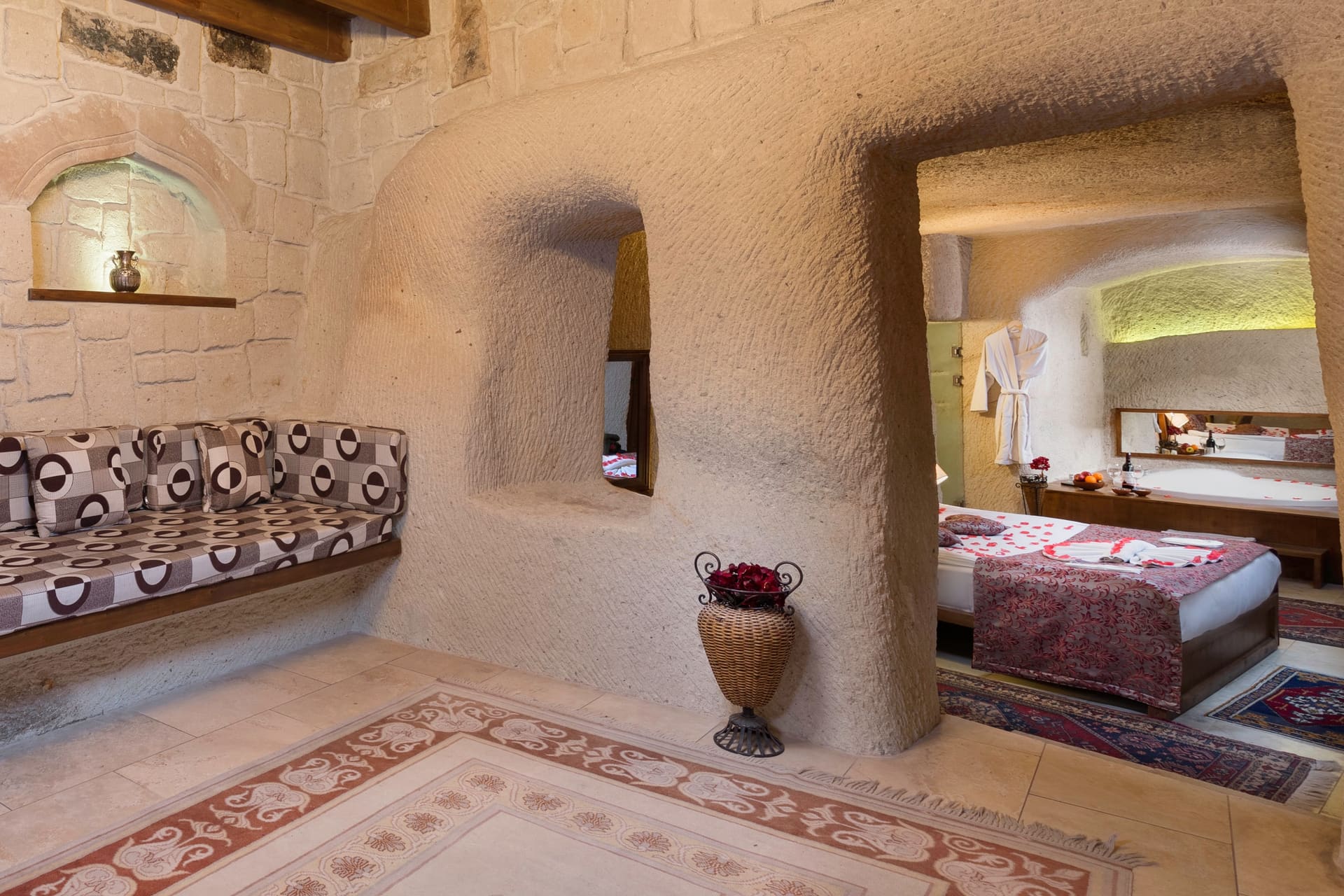 Room 111, King Cave Suite: view through the cave archway into the bedroom, a vase in a wall niche, the patterned bench in front