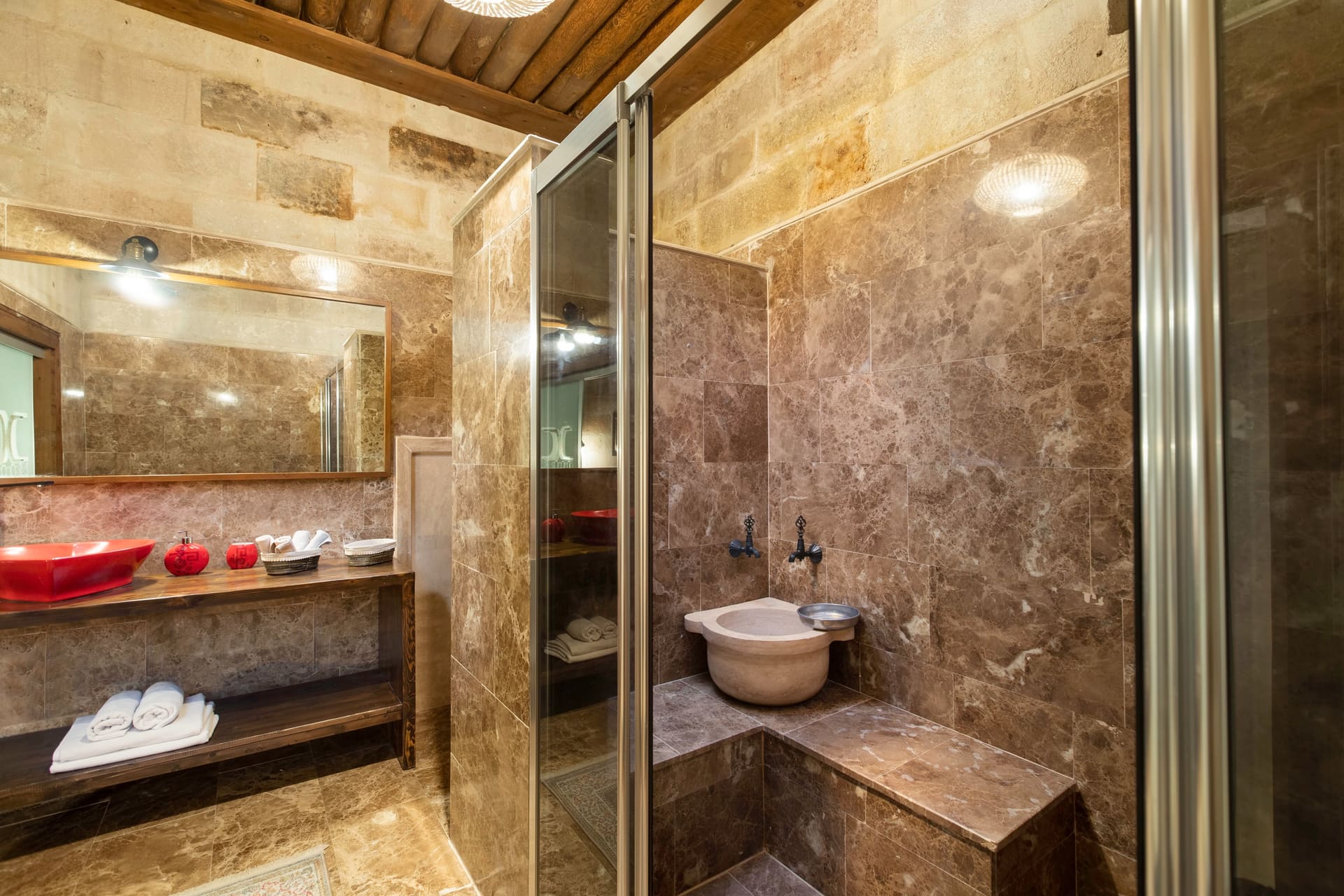 Room 110, Queen Suite: Bathroom with a glass shower stall, stone tiling and towels.