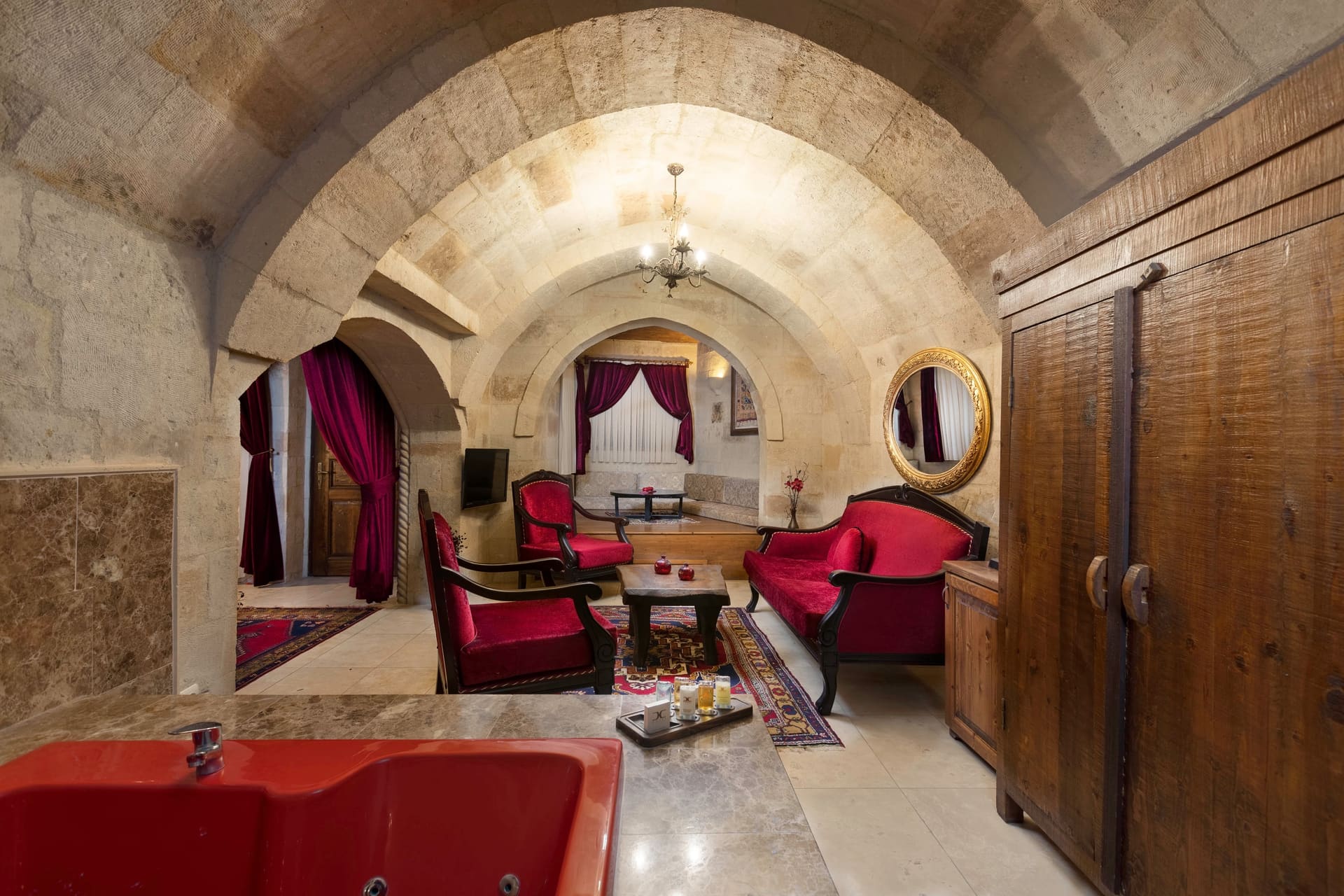 Room 110, Queen Suite: Wide view along the vaulted stone ceiling with a wardrobe and the bed in the distance.