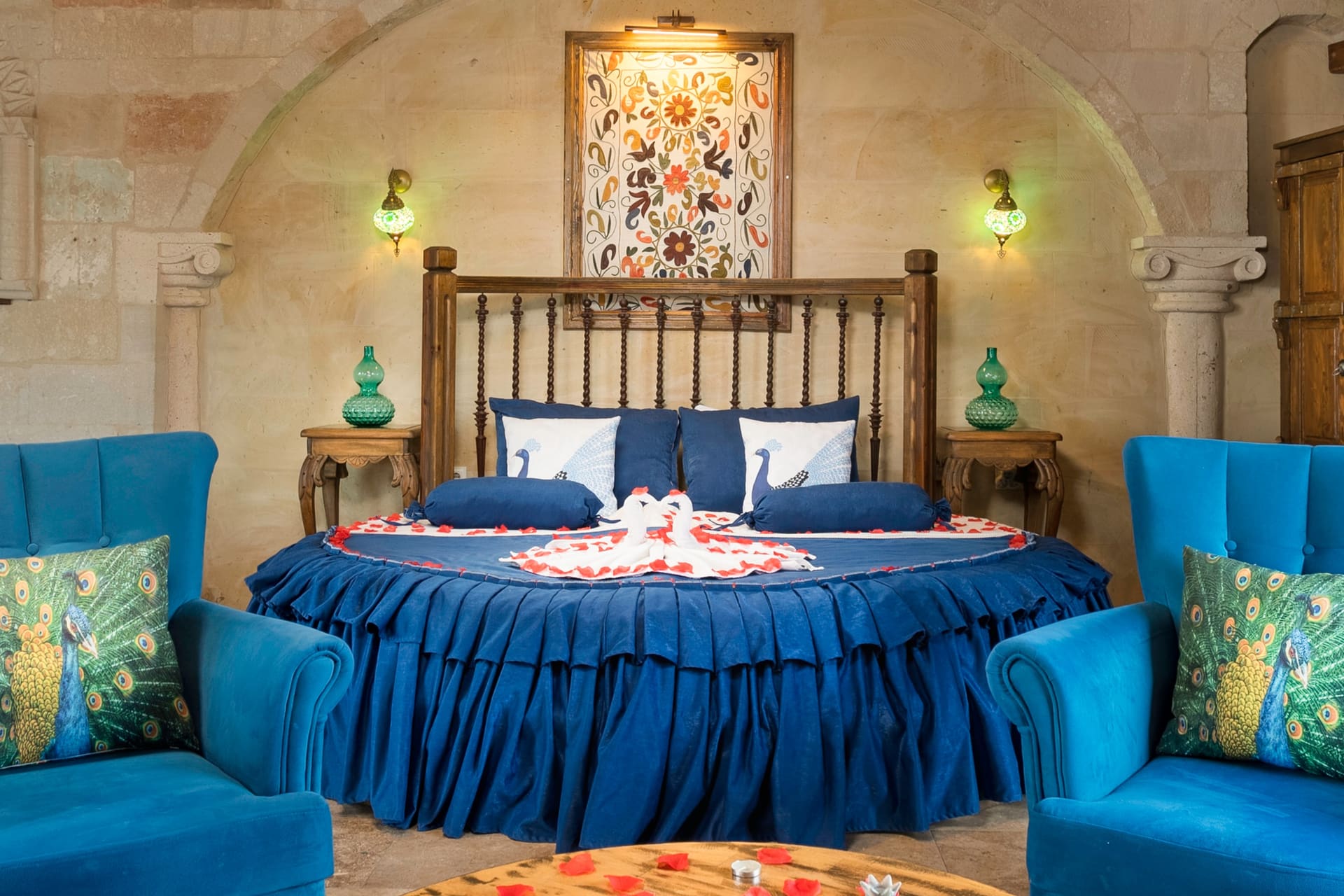 Room 120, Queen Suite: Close view of the round bed with a blue armchair beside it.