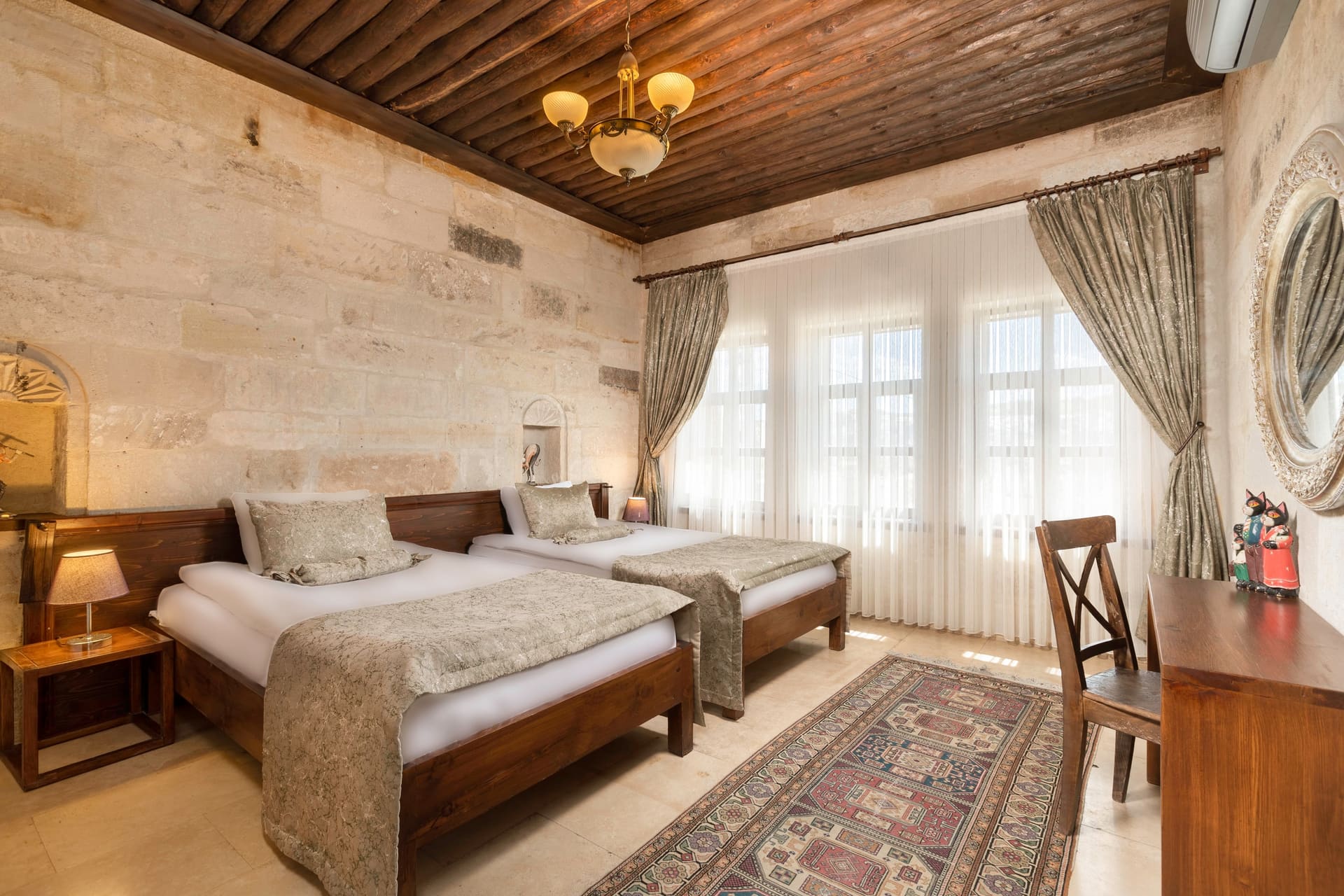 Room 117, Junior Suite: Two twin beds, patterned bedspreads, curtained windows, wood-beamed ceiling.