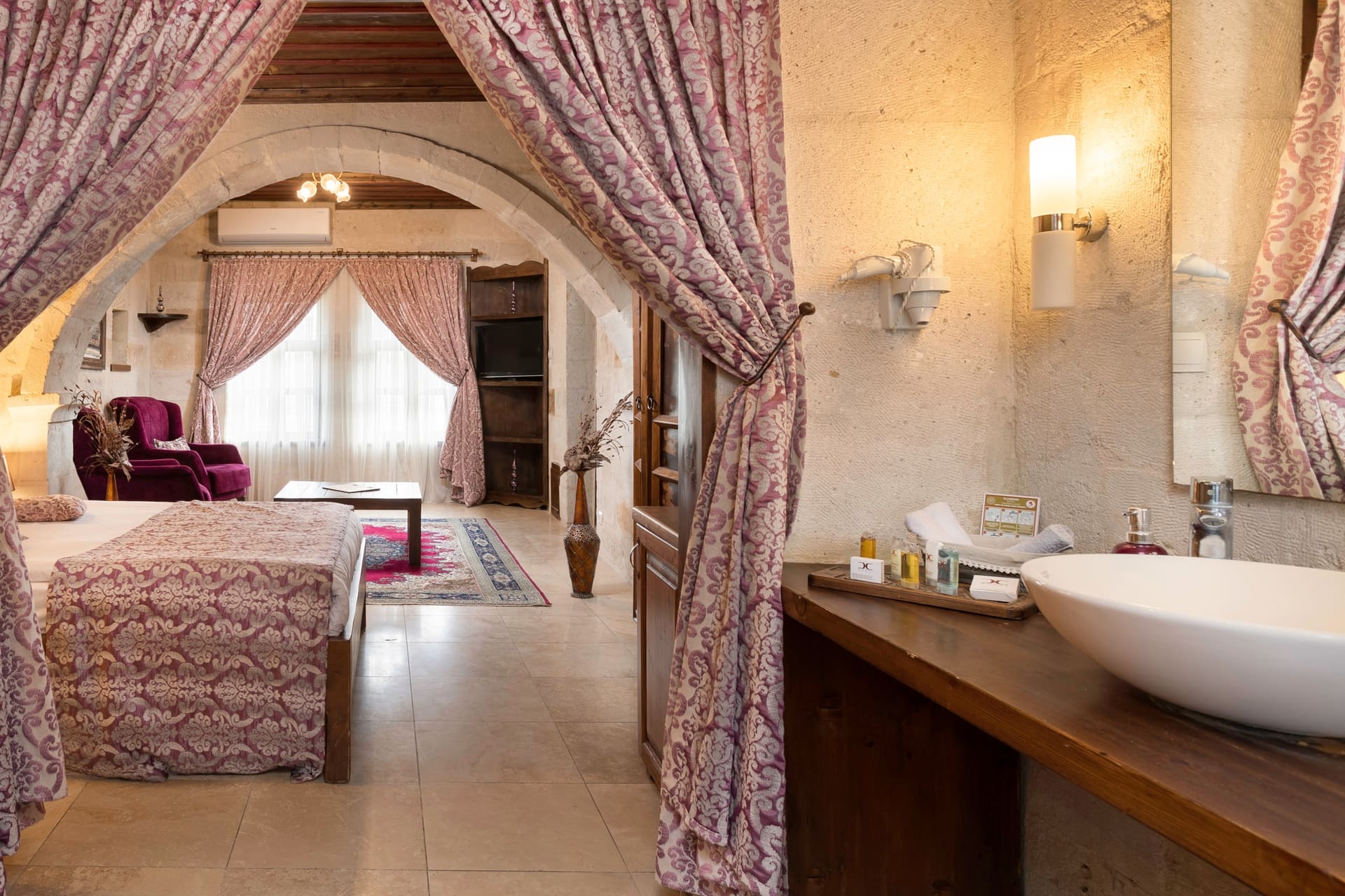 Room 105, King Suite: the double vanity sink with a purple armchair reflected in the mirror