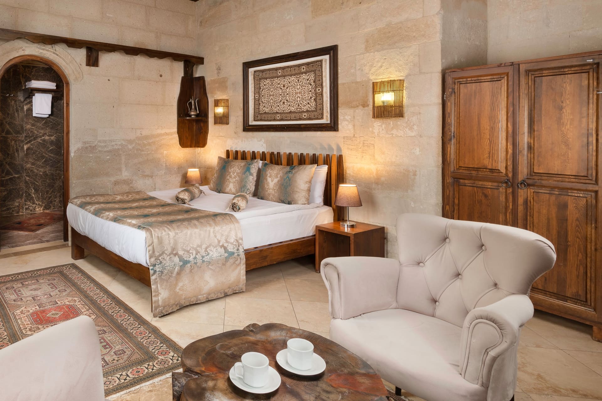 Room 103, Deluxe: Bed, cabinet, framed artwork on the wall, seating area behind