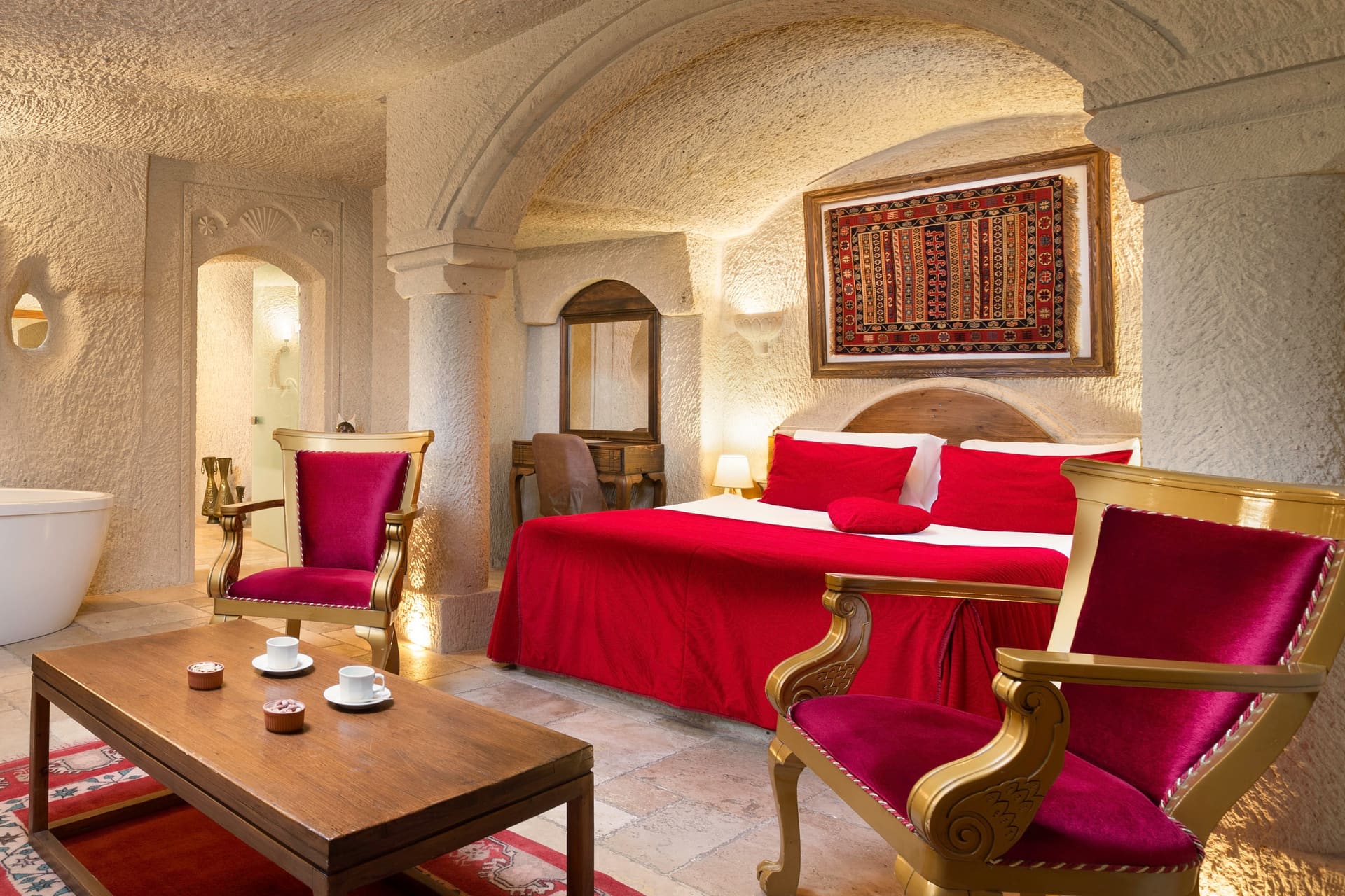 Room 115, Junior Cave Suite: wide view of the room, freestanding tub, chairs and bed