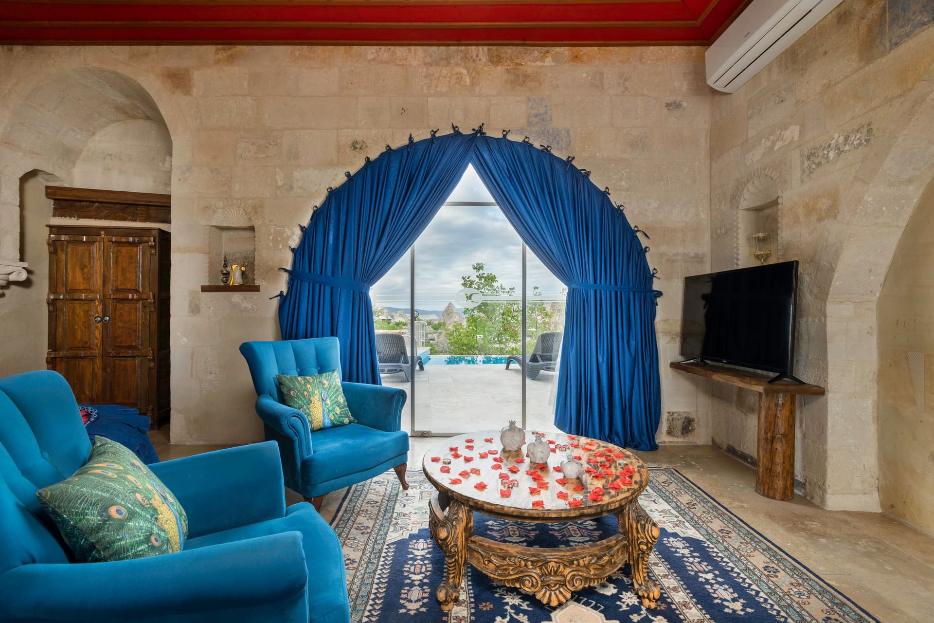 Room 120, Queen Suite: Blue armchair seating area facing the open arched terrace door.