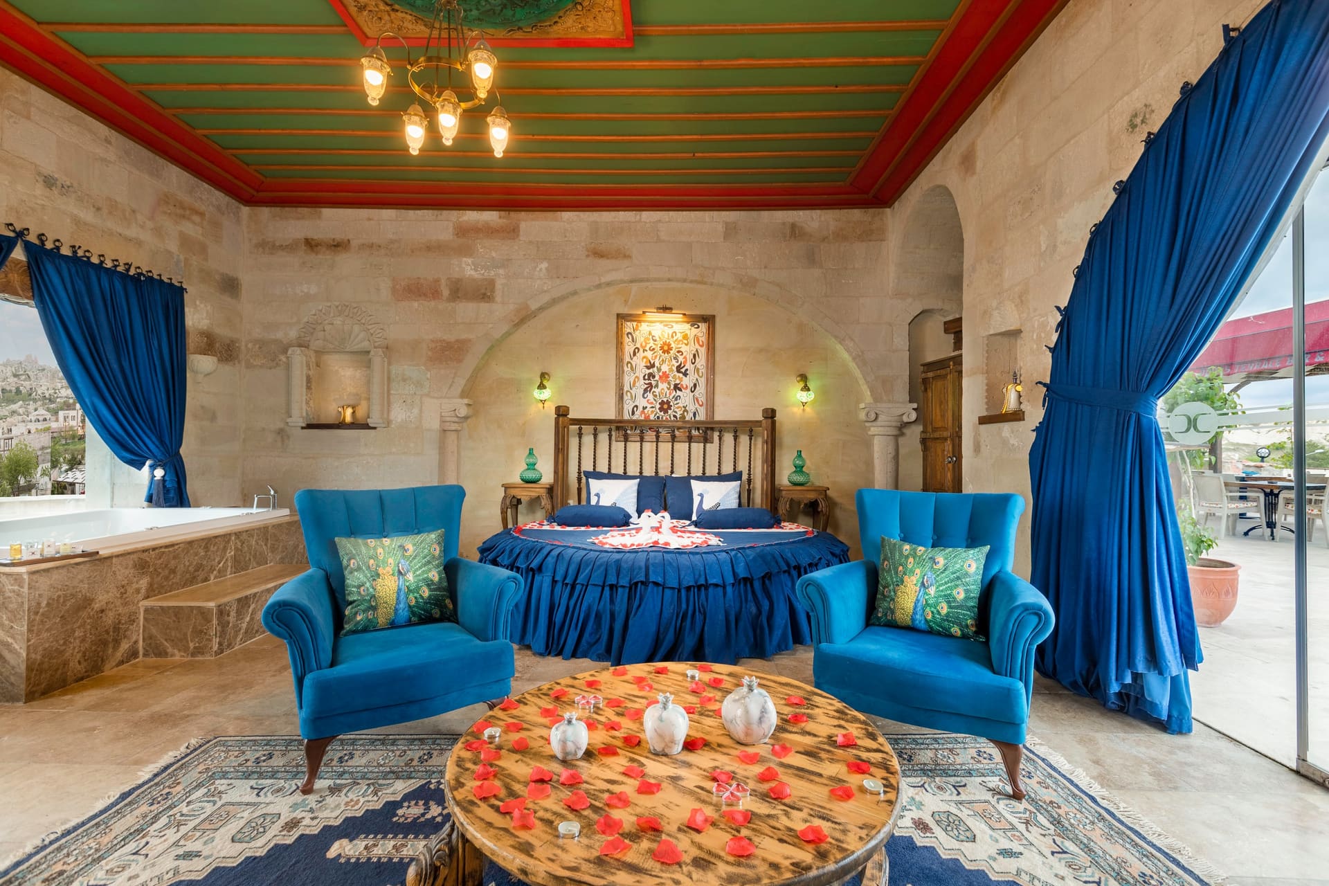 Room 120, Queen Suite: Round bed and the edge of the jacuzzi tub beneath a painted ceiling.