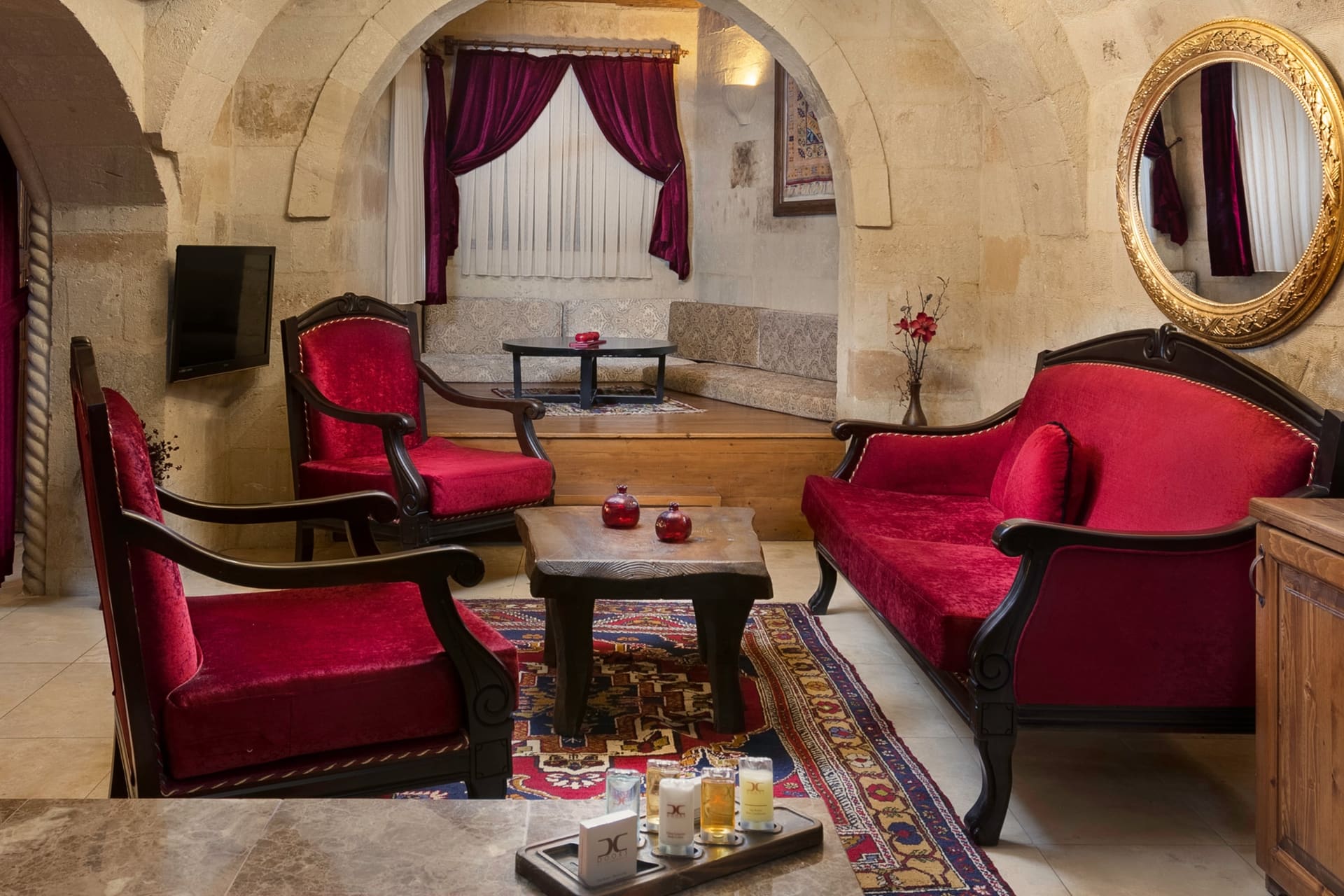 Room 110, Queen Suite: A corner with red armchairs, an oval mirror and a curtain.