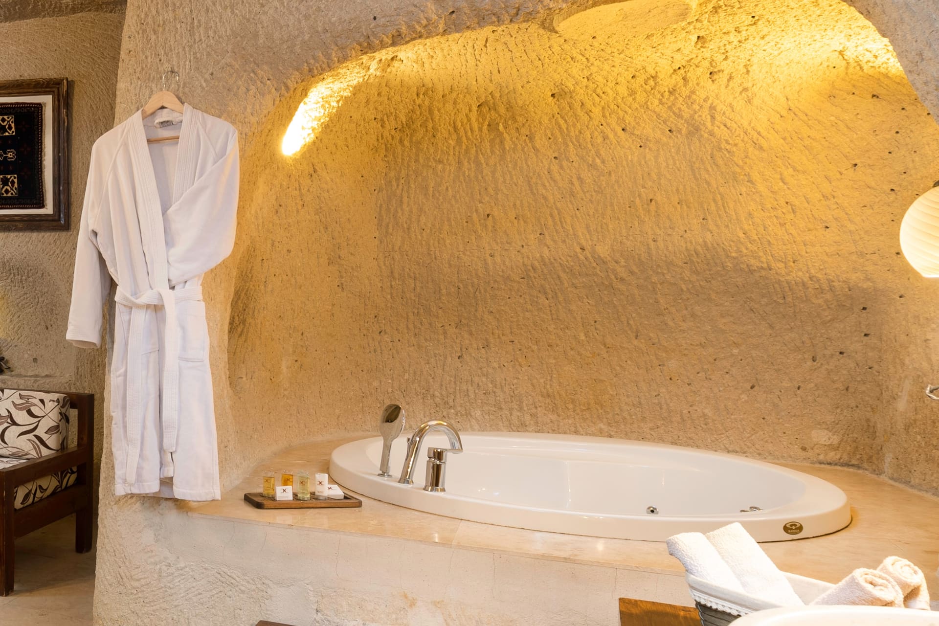 Room 113, Junior Cave Suite: hanging robe, oval bathtub, sink, candles