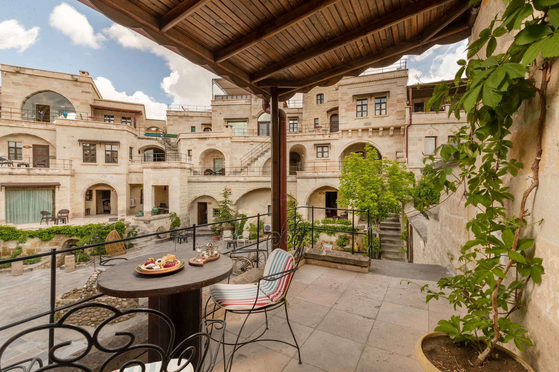 Room 118, Deluxe: View from the terrace over the courtyard and buildings, seating table