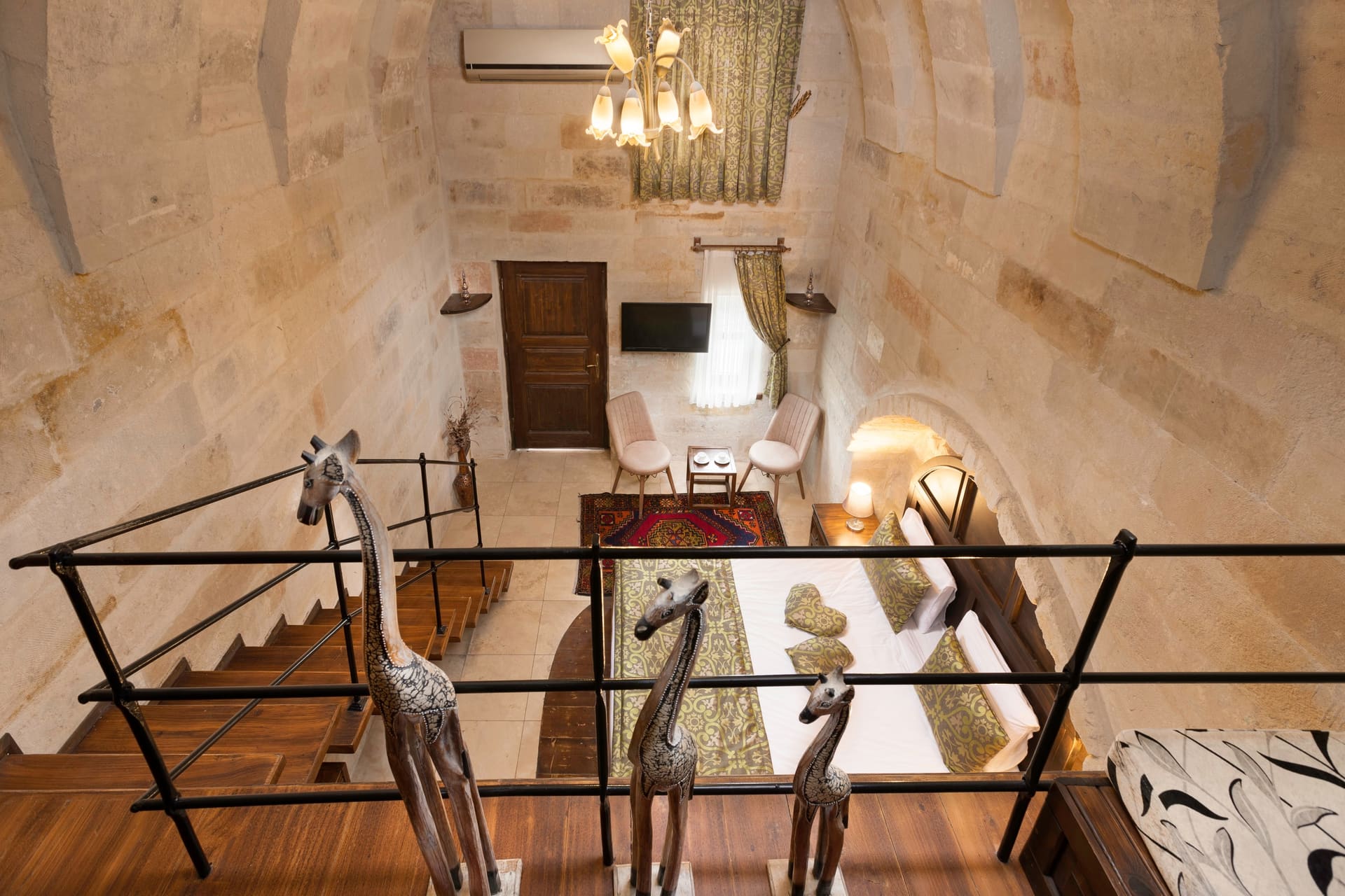 Room 104, Junior Suite: Mezzanine loft, wooden railing, carved giraffe figures, desk below.