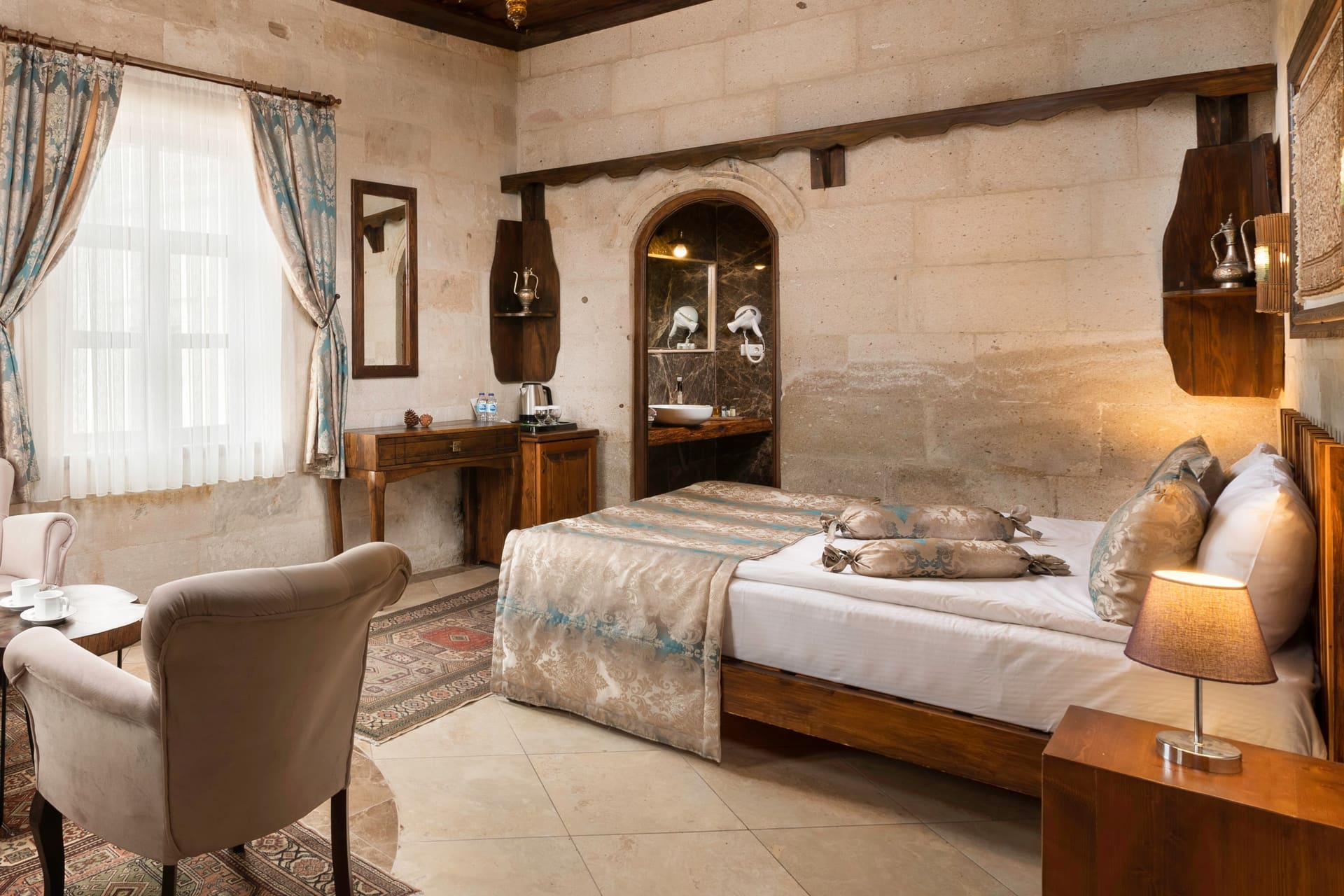 Room 103, Deluxe: Bed alone in frame, wardrobe and door, armchair to the side