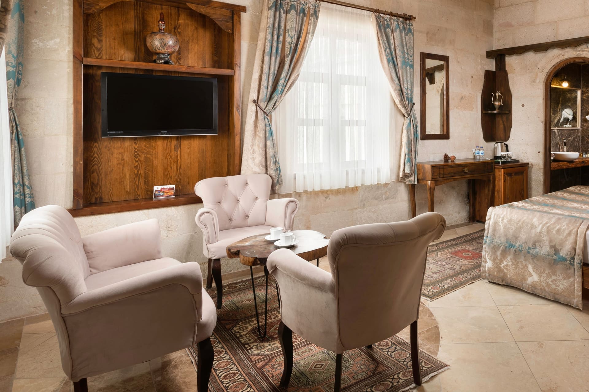 Room 103, Deluxe: Bed, arched passage, cabinet, overview of the seating area