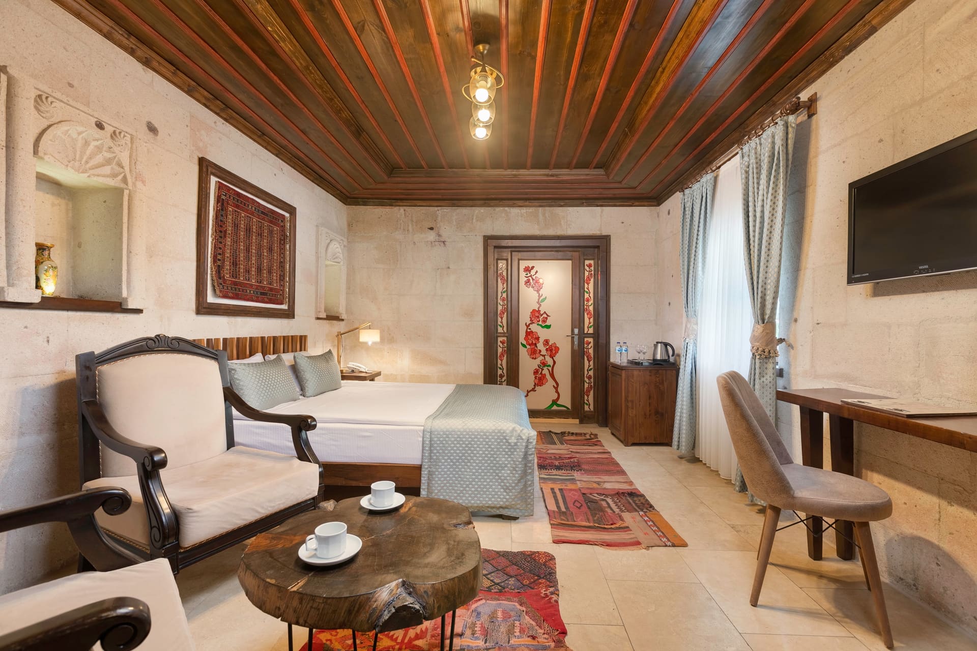 Room 116, Deluxe: Bed with a small table and armchair beside it, wall artwork
