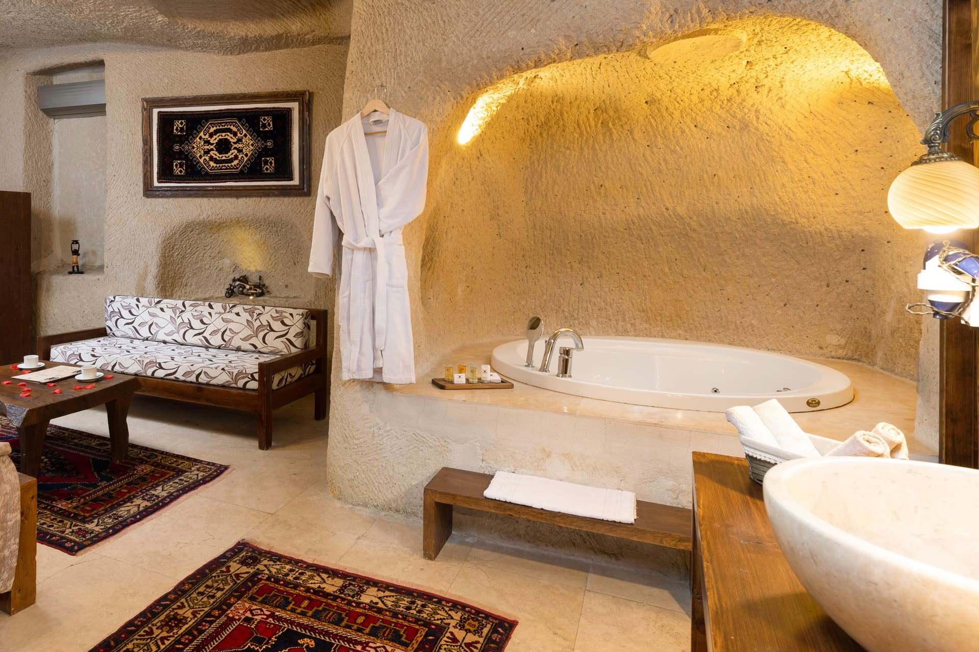 Room 113, Junior Cave Suite: hanging robe in the bathroom, tub, wooden bench, rug