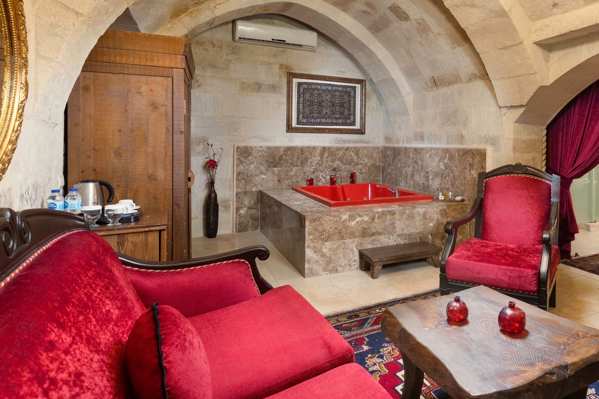 Room 110, Queen Suite: The jacuzzi corner with a tea and coffee tray and armchairs.