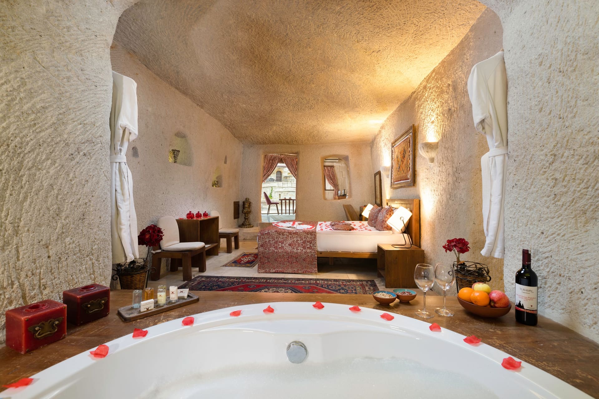 Room 111, King Cave Suite: view from the tub toward the bed, a seating nook in the corner, the terrace door beyond