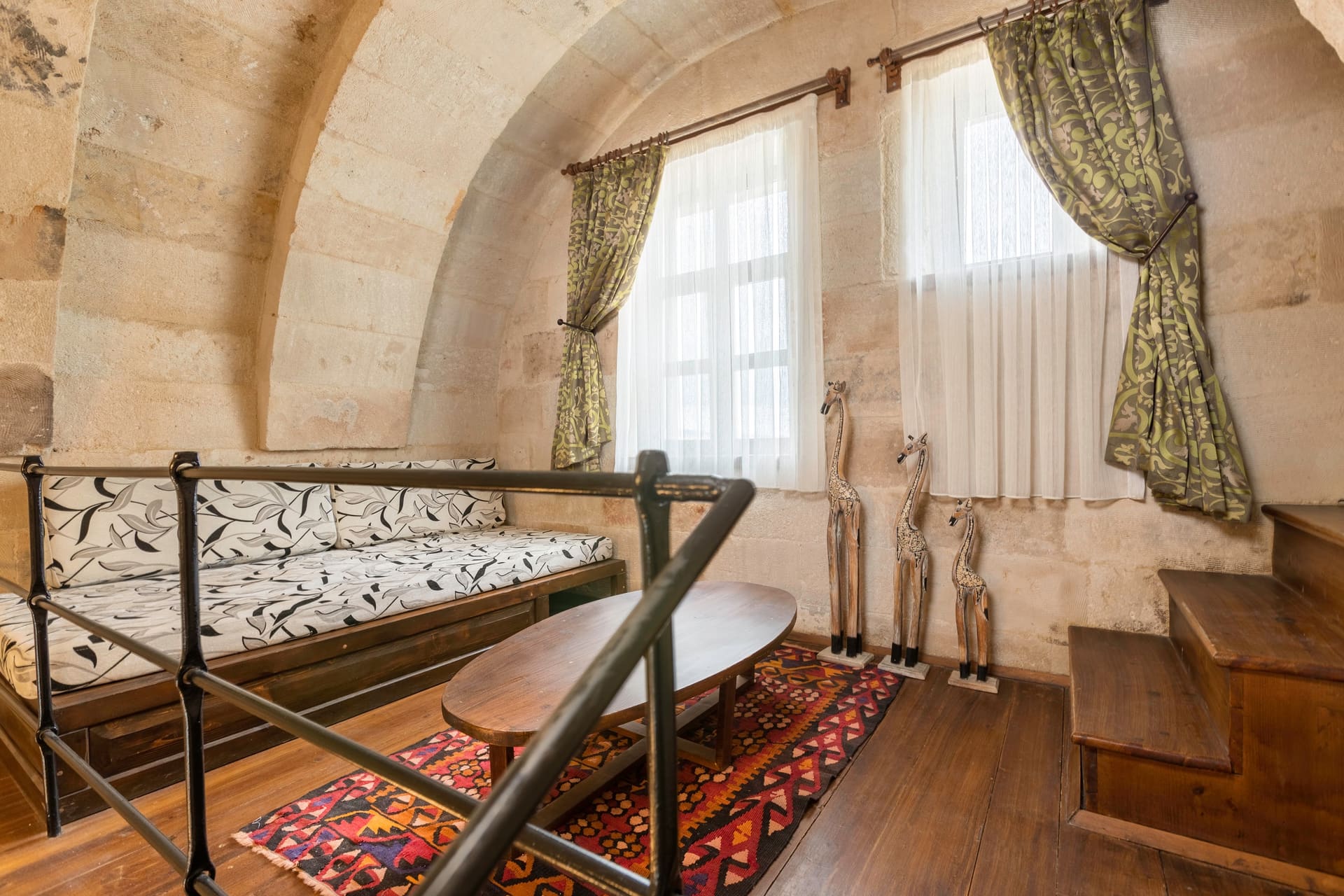 Room 104, Junior Suite: Mezzanine railing, view down to bed and patterned rug below.