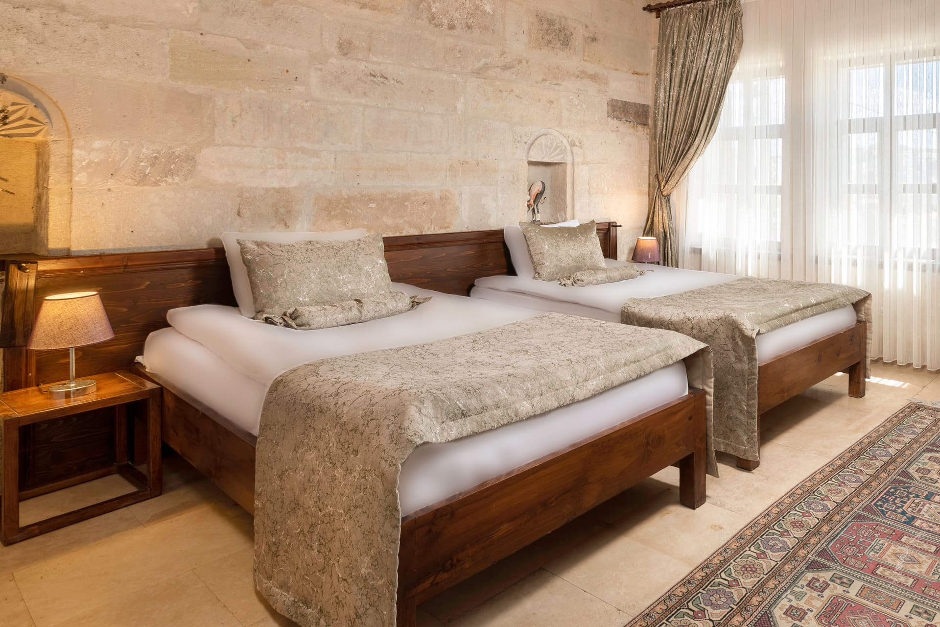 Room 117, Junior Suite: Close-up of twin beds, wooden headboards, nightstand, windows.