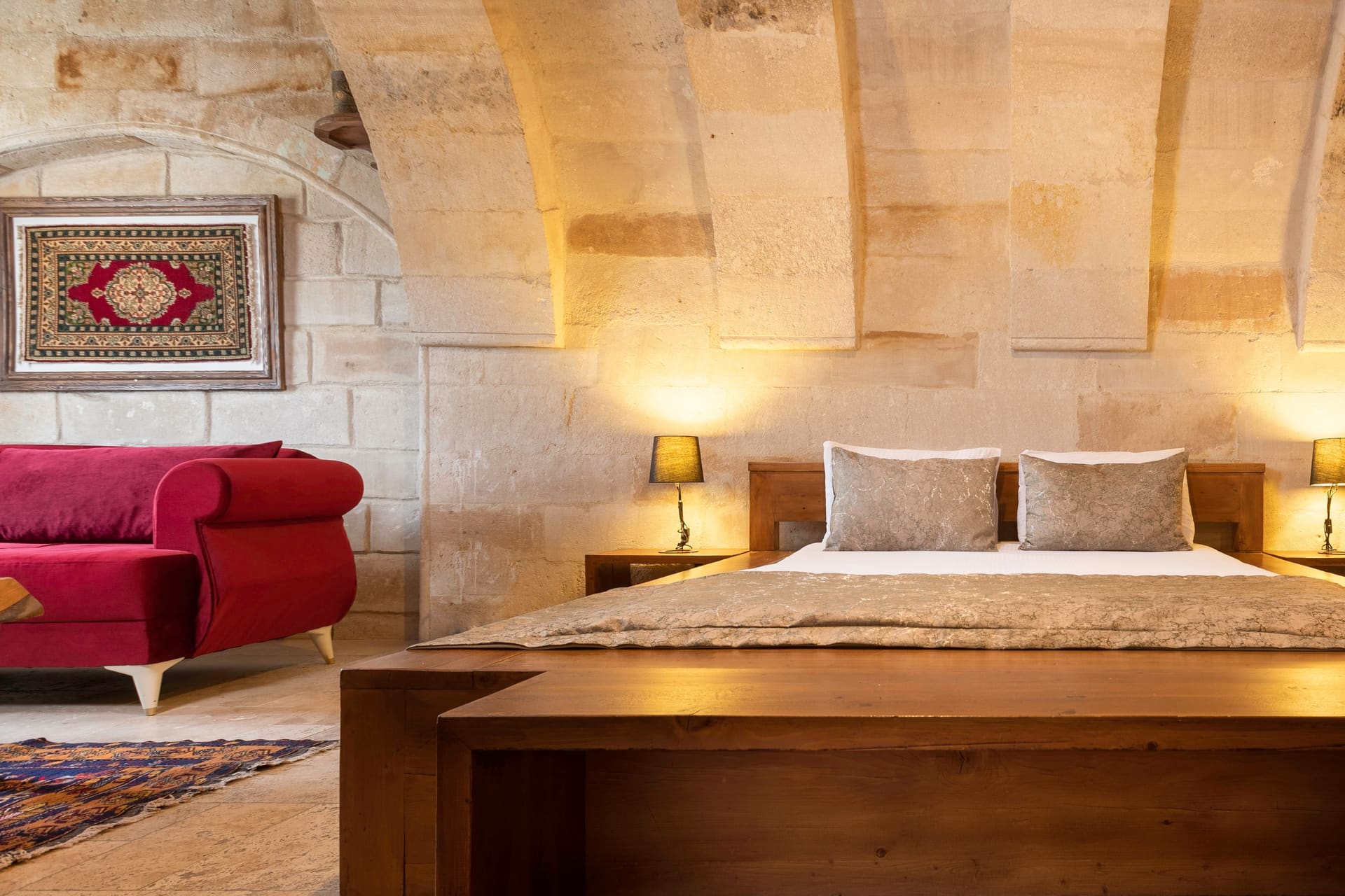 Room 108, Junior Suite: Red chaise chairs flanking the bed, lamps, wall art.
