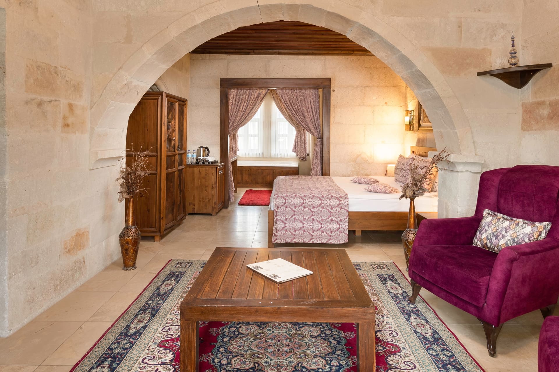 Room 105, King Suite: another angle through the arch showing the wardrobe and the patterned bedspread