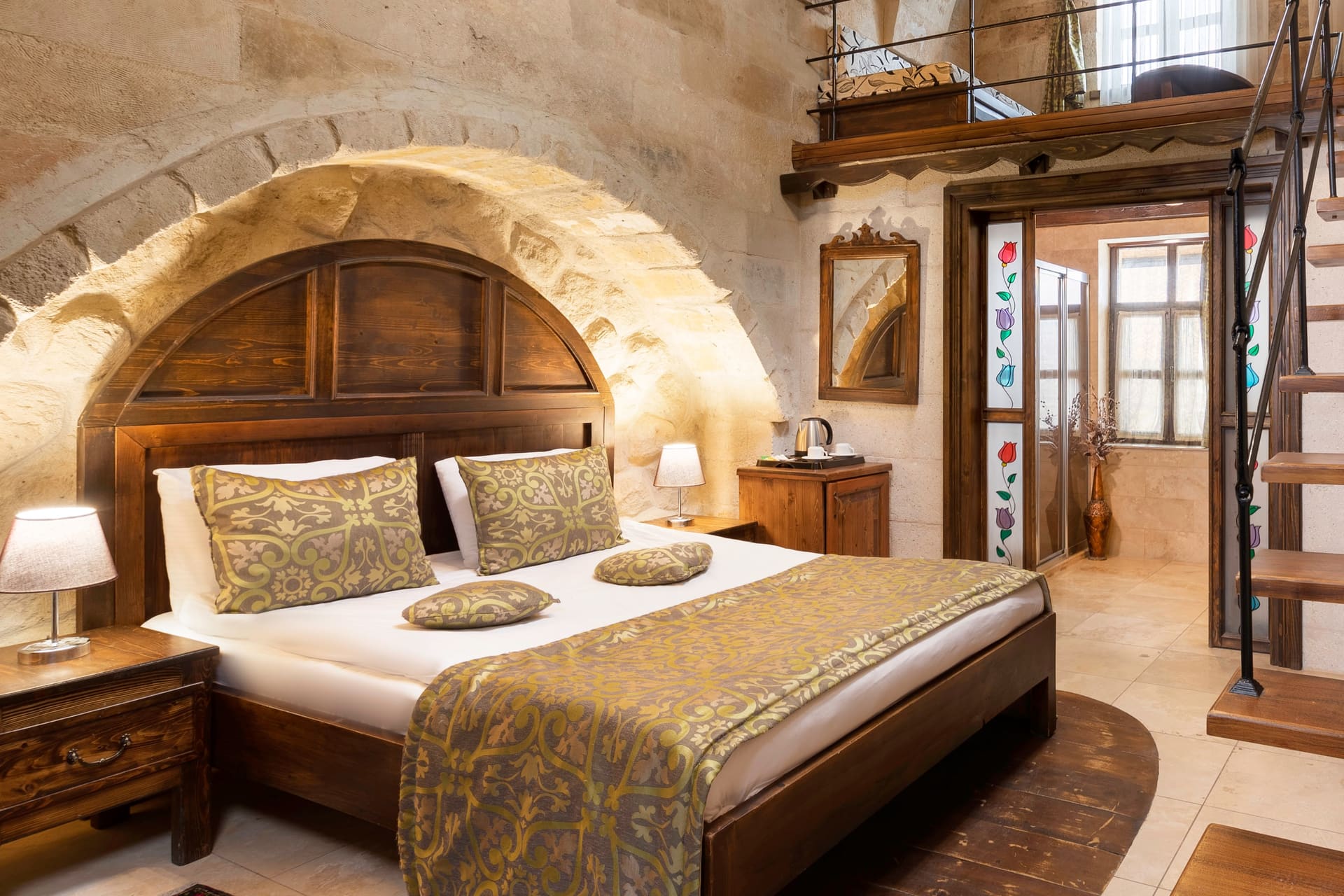 Room 104, Junior Suite: Arched bed alcove, wall sconce, framed picture, patterned bedspread.