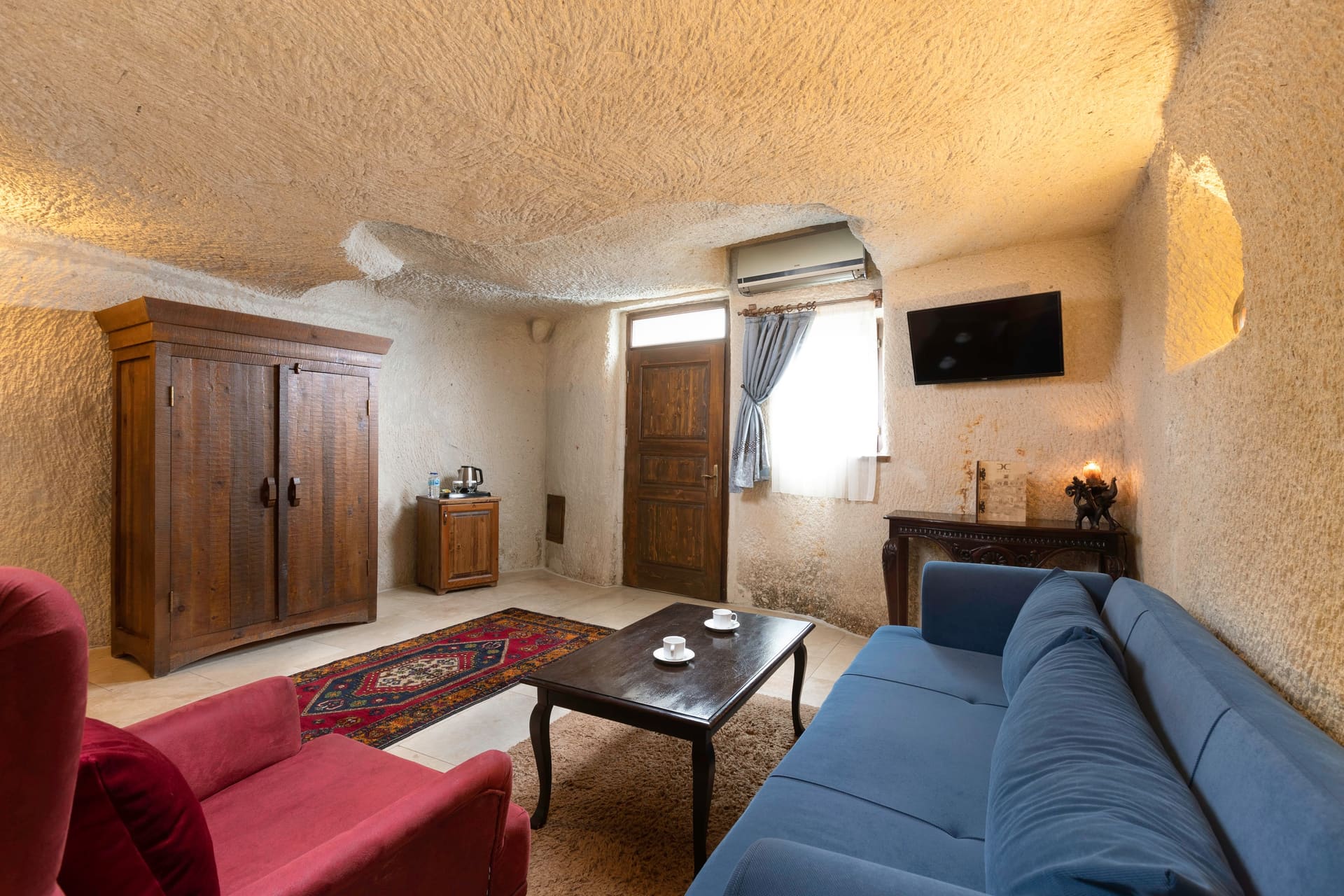 Room 114, Junior Cave Suite: bed alcove, wall-mounted TV, wardrobe, seating area