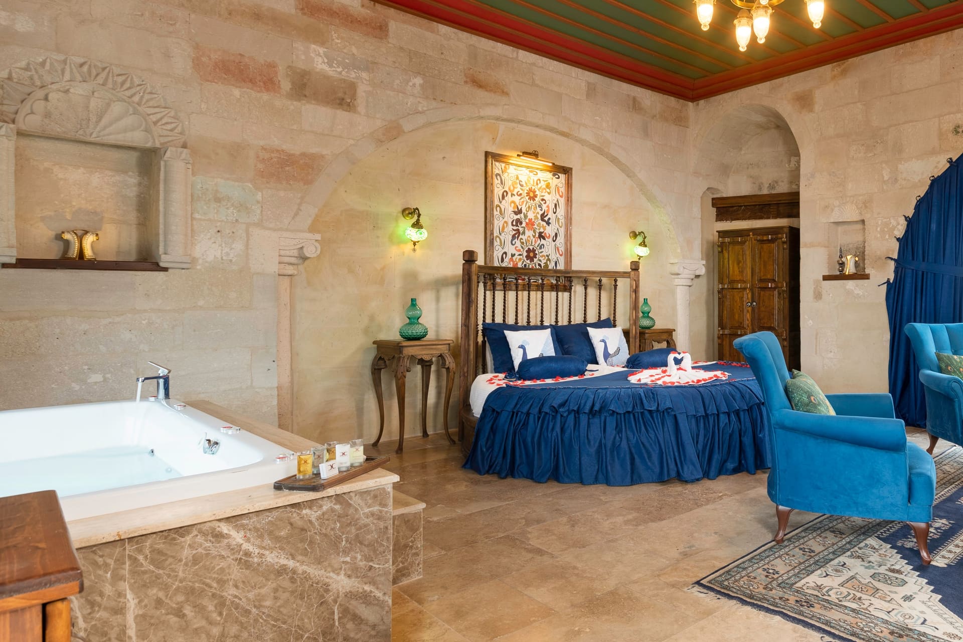 Room 120, Queen Suite: Jacuzzi tub and the edge of the bed, decorative niche.