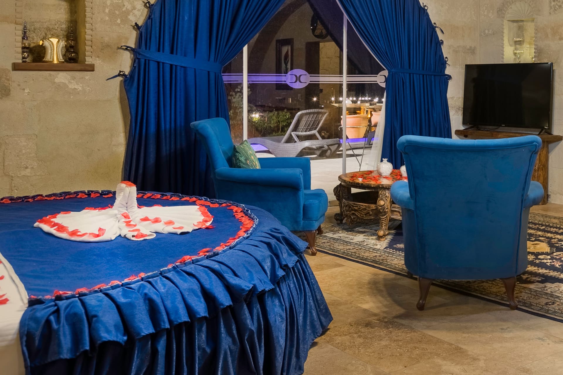 Room 120, Queen Suite: Round bed, wall-mounted TV, door to the terrace.